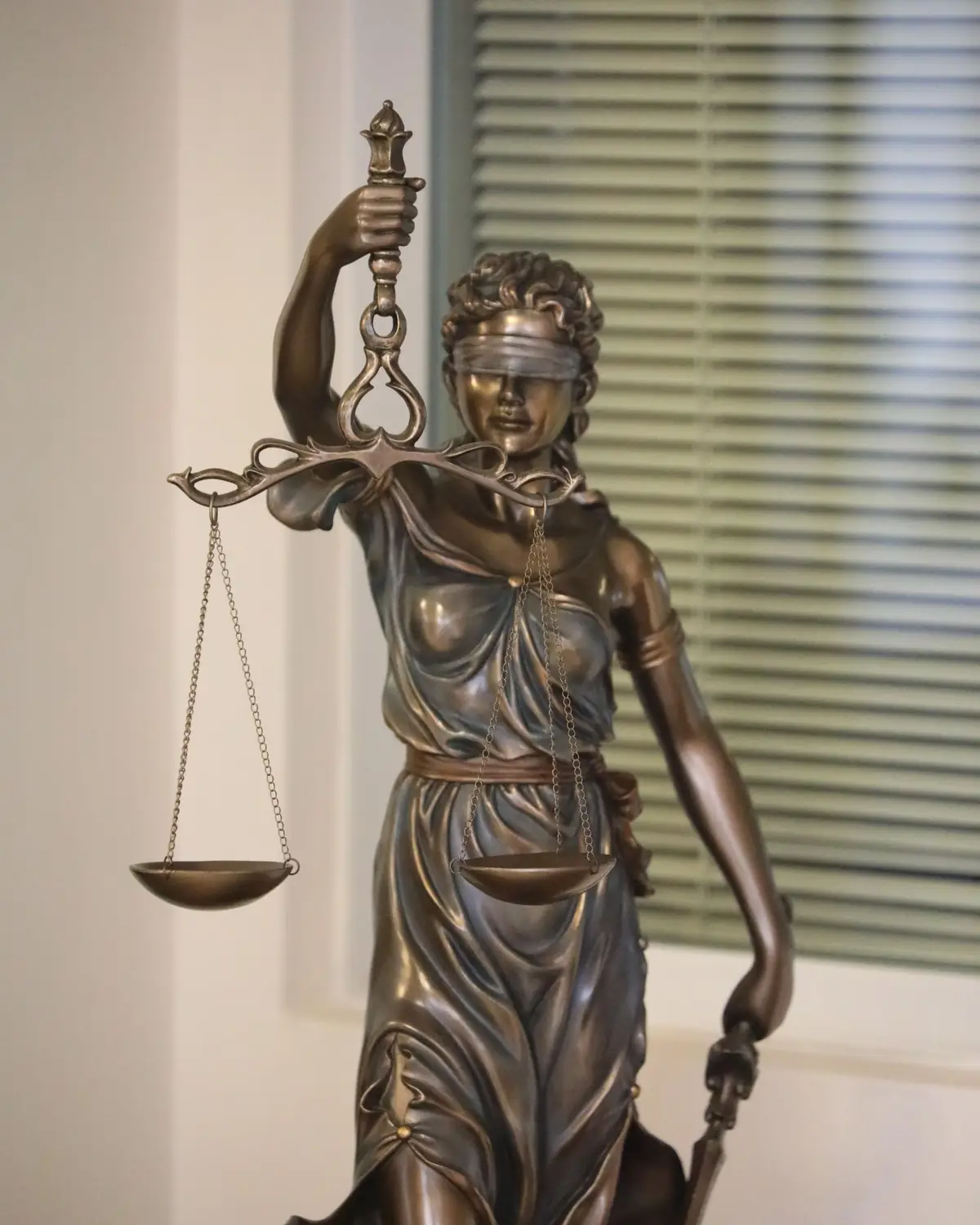 Çalışma masasında terazi tutan adalet heykeli