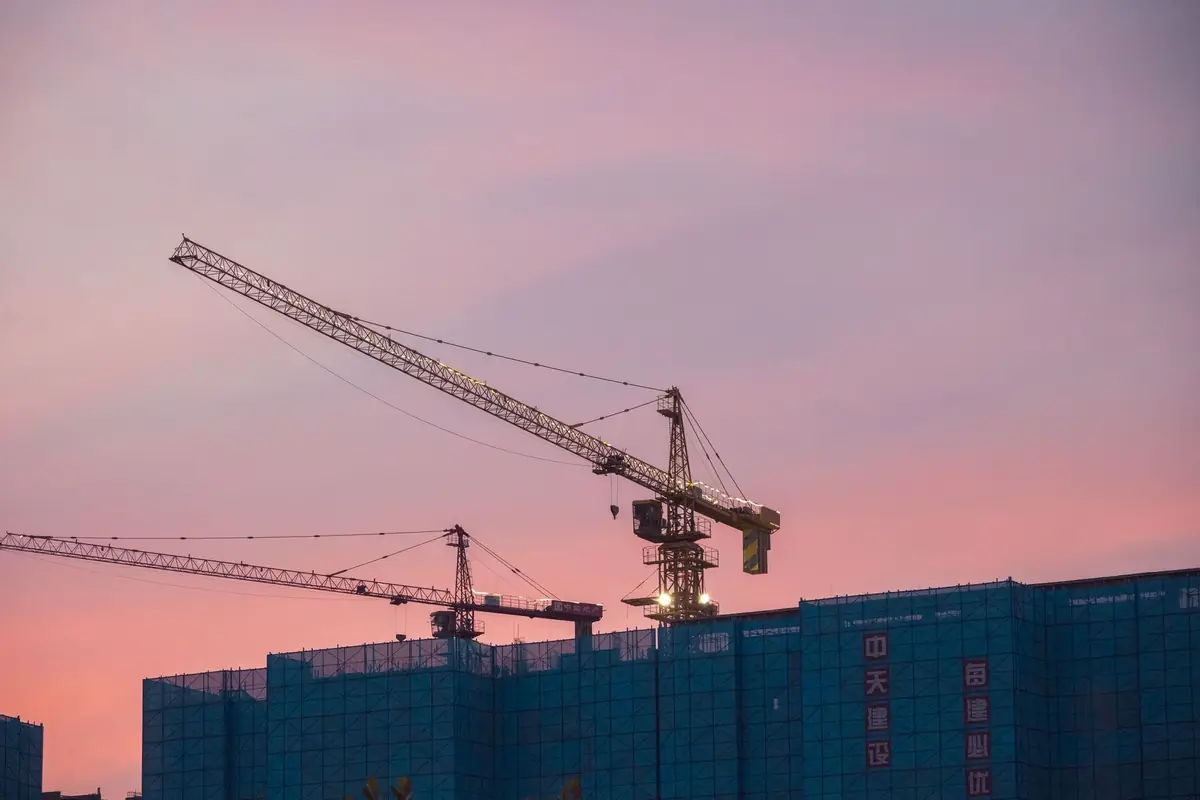 Gün batımında inşaat hâlindeki bina ve kule vinci
